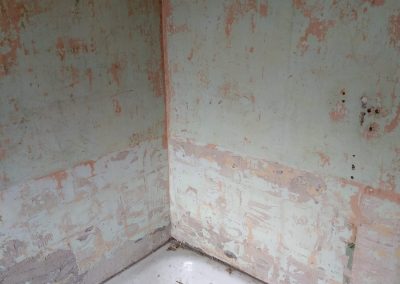 a stripped bathroom wall ready for decorating