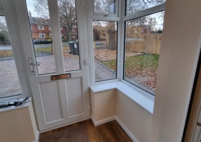 a new porch area with white front door and double glazed windows and wooden floor