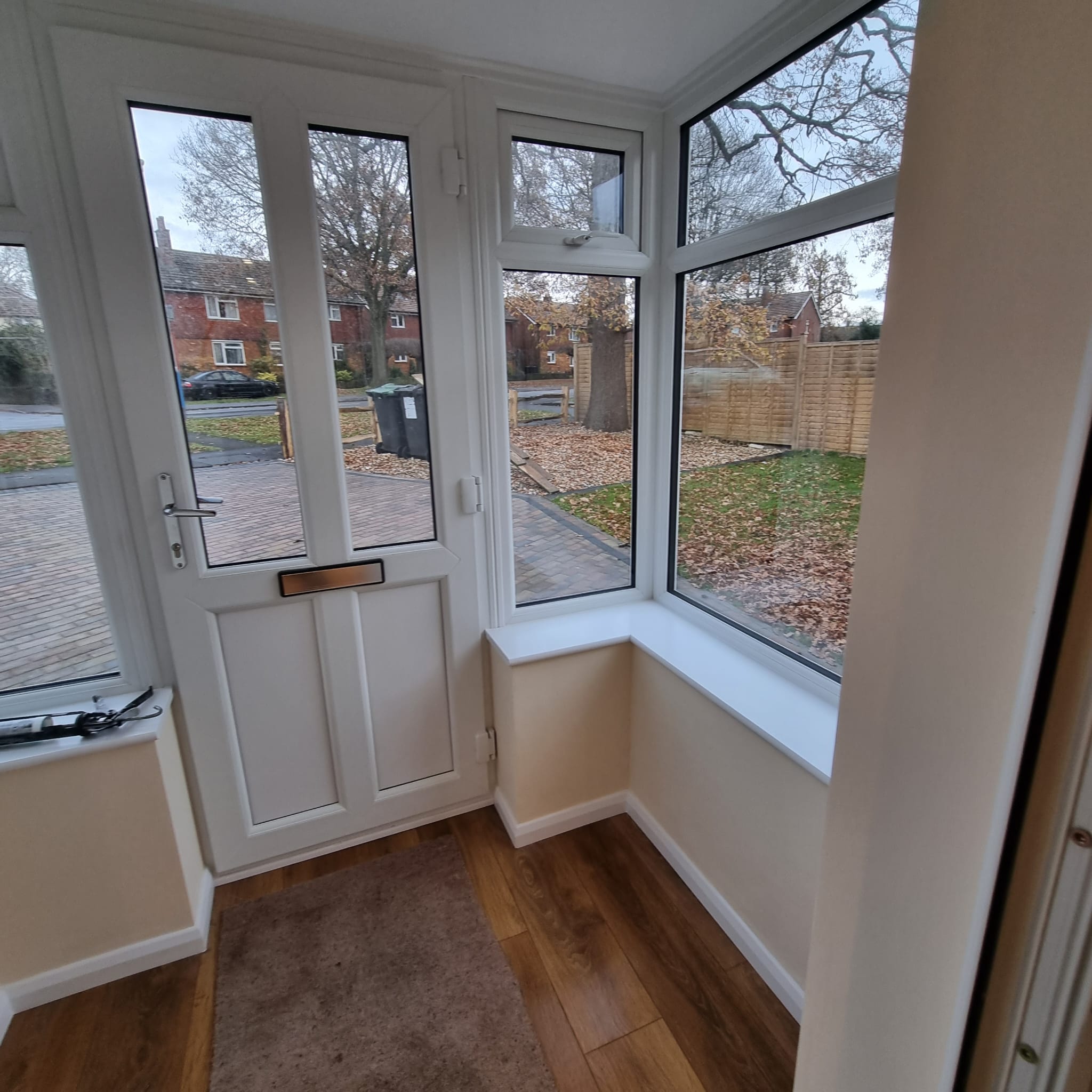 a new porch area with white front door and double glazed windows and wooden floor