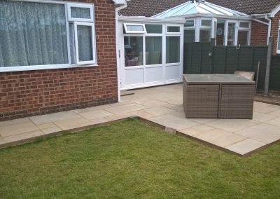 back garden with new small patio and white pvc conservatory. Has a newly laid turf lawn area.
