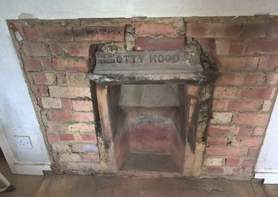 an old brick fireplace with an Otty hood brick over the top