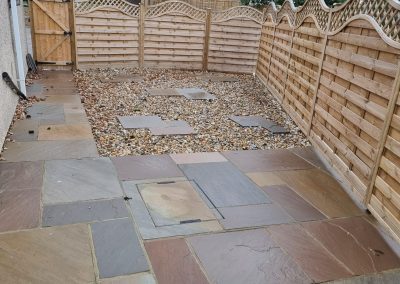 a new small patio area with gravelled section and light new fencing with sculpted trellis on top